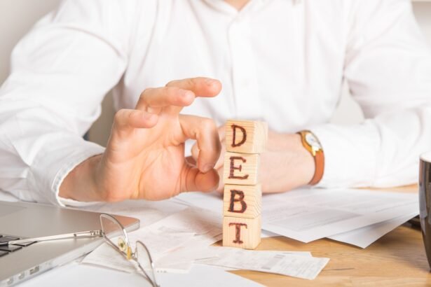 Businessman removes wooden blocks with the word Debt. Reduction or restructuring of tax. Bankruptcy announcement. Refusal to pay loans and invalidate them.